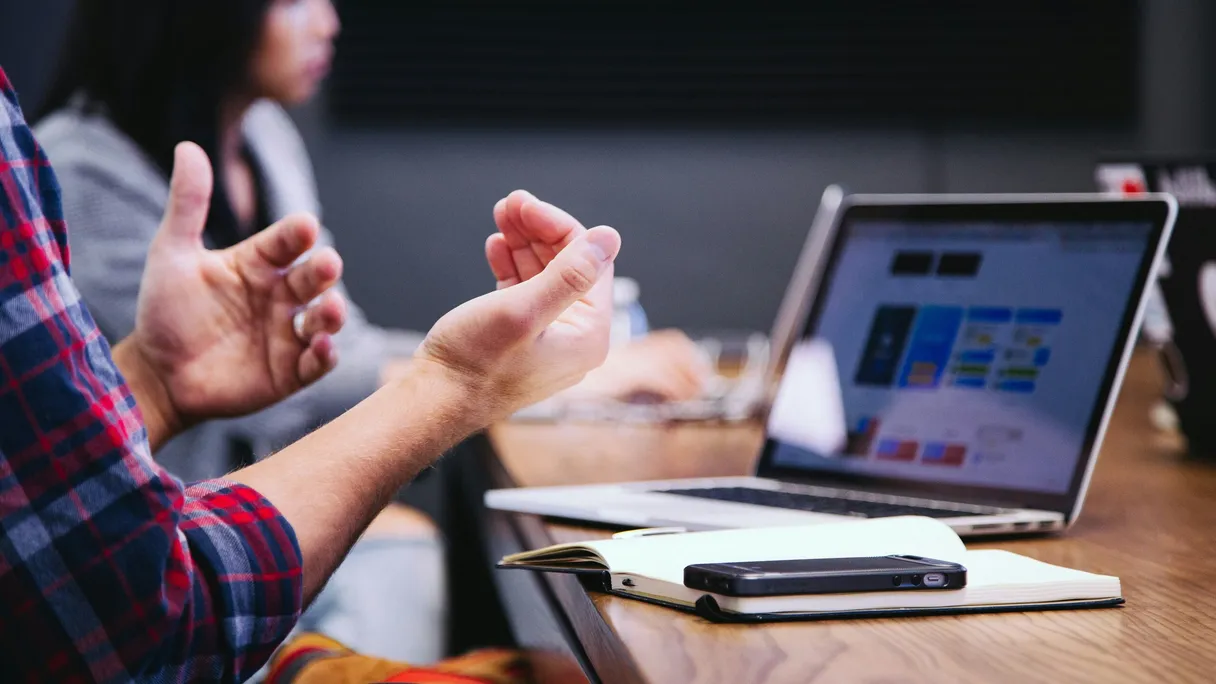A team discusses the scope of a first version of a custom web application at a worktable.